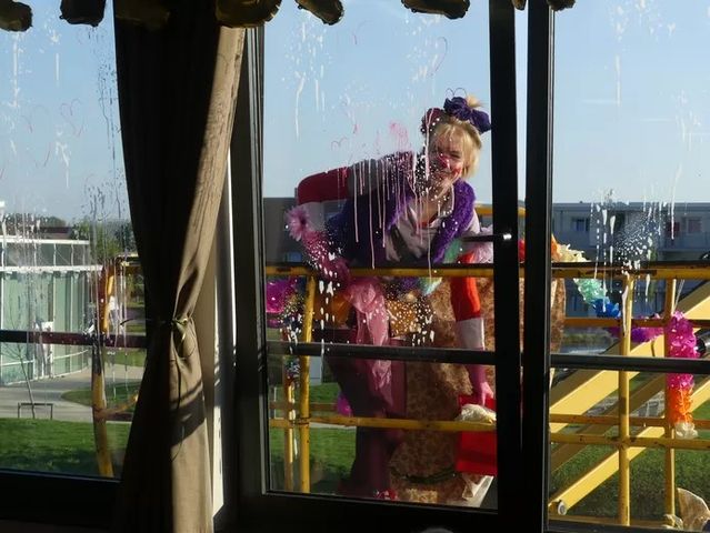 WZC Karel Picqué ontvangt glazenwassende clown in hoogtewerker